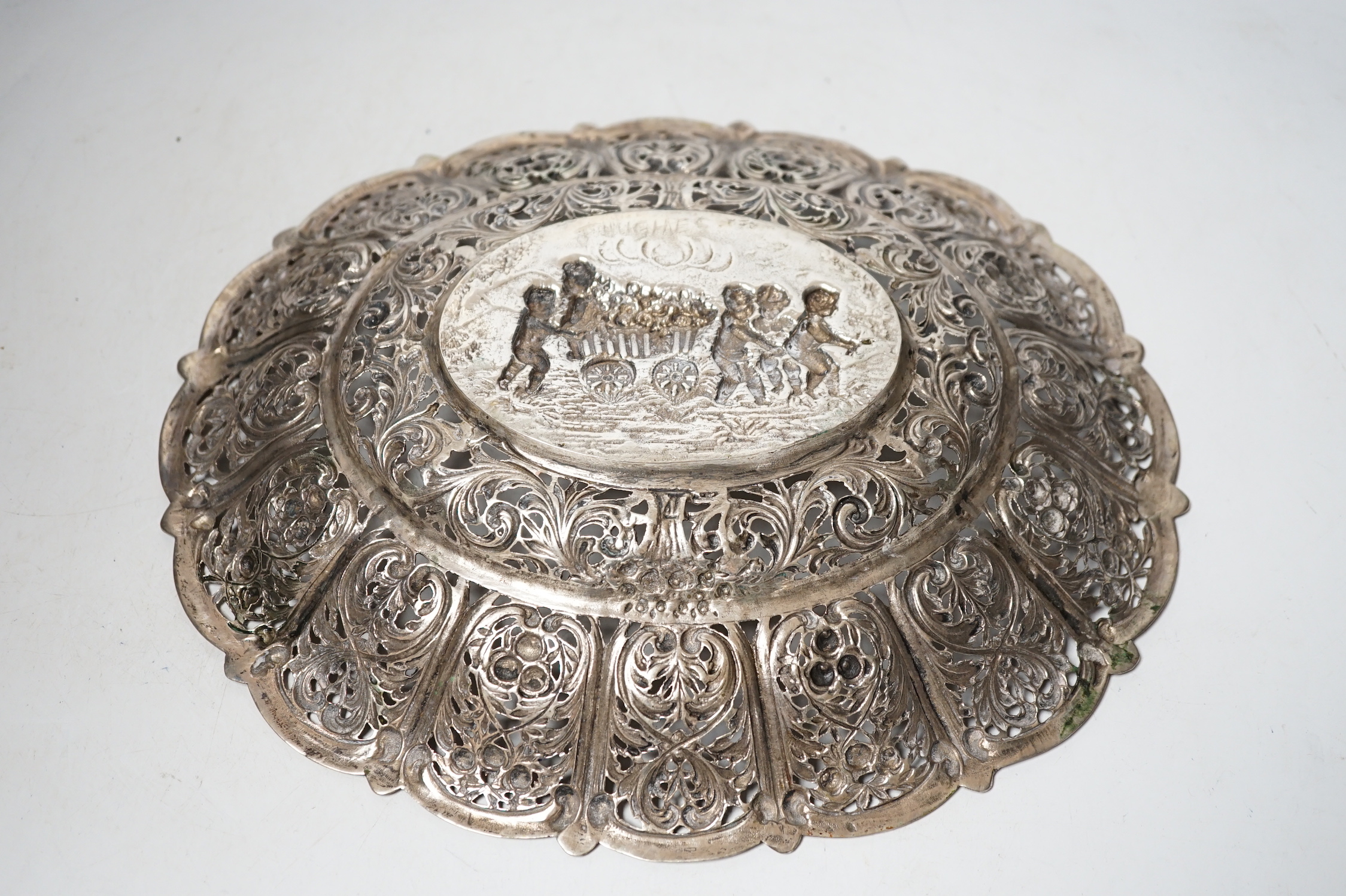 An early 20th century German 800 standard pierced white metal oval dish, decorated with putti and cart of flowers, 29.7cm, 13.2oz.